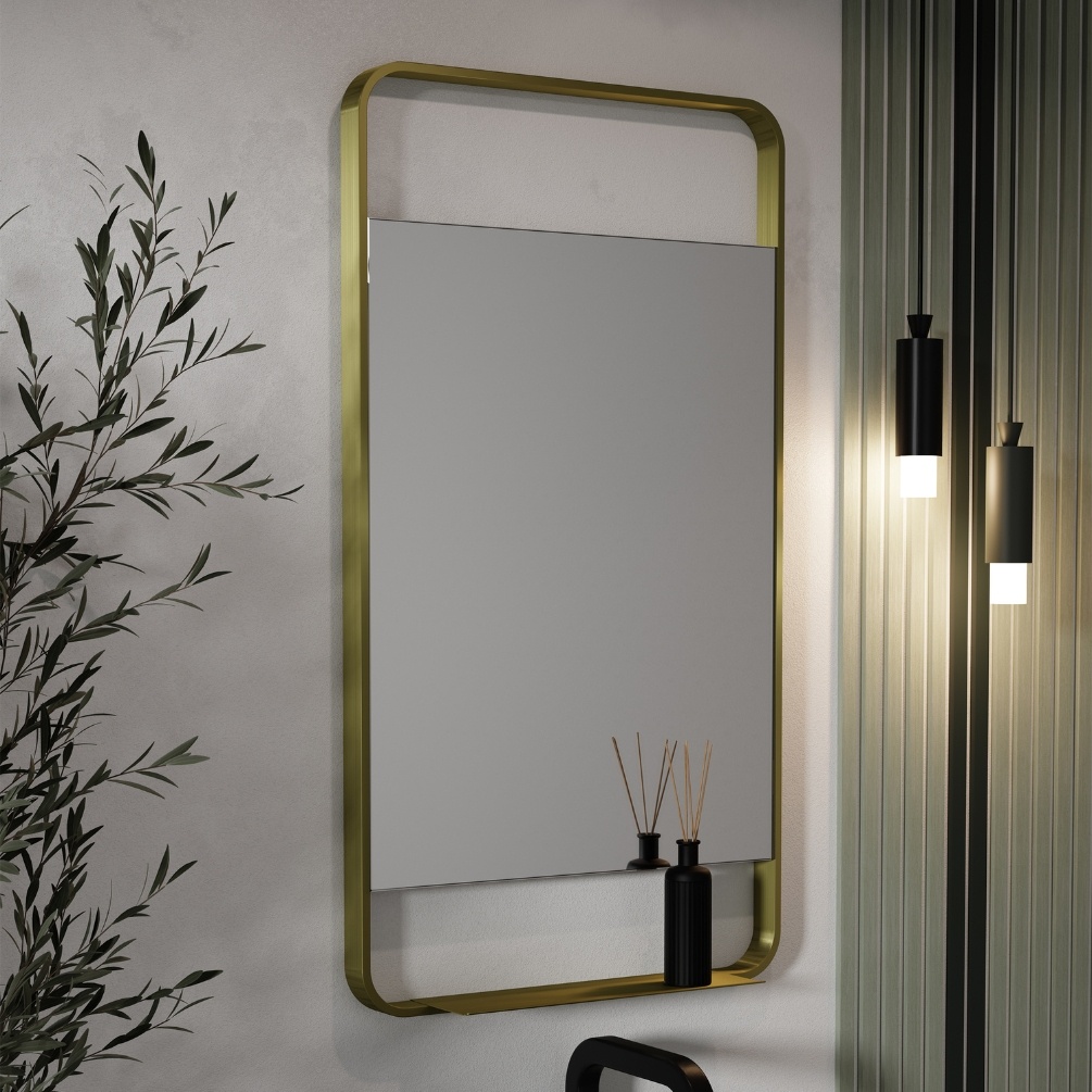 Lifestyle image of the Origins Living Ludgate 550mm x 1000mm Brushed Brass Mirror with Shelf mounted on a white bathroom wall. LDG-002510-BB